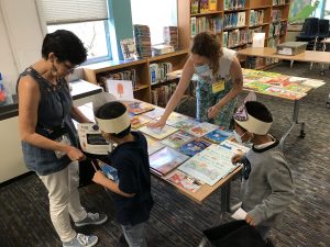 Program Associate Jessy helps students choose books at Wooten Summer Success.